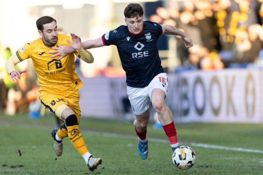 Ross County's George Harmon holds-off Livingston's Scott Pittman during the match, at which the behaviour of some young fans during the minute's silence left the club dismayed.