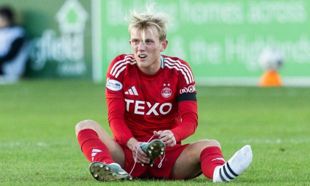 Aberdeen's Alexander Jensen puts one of his boots back on during the Scottish Cup victory at Elgin City two weekends ago. Image: SNS.