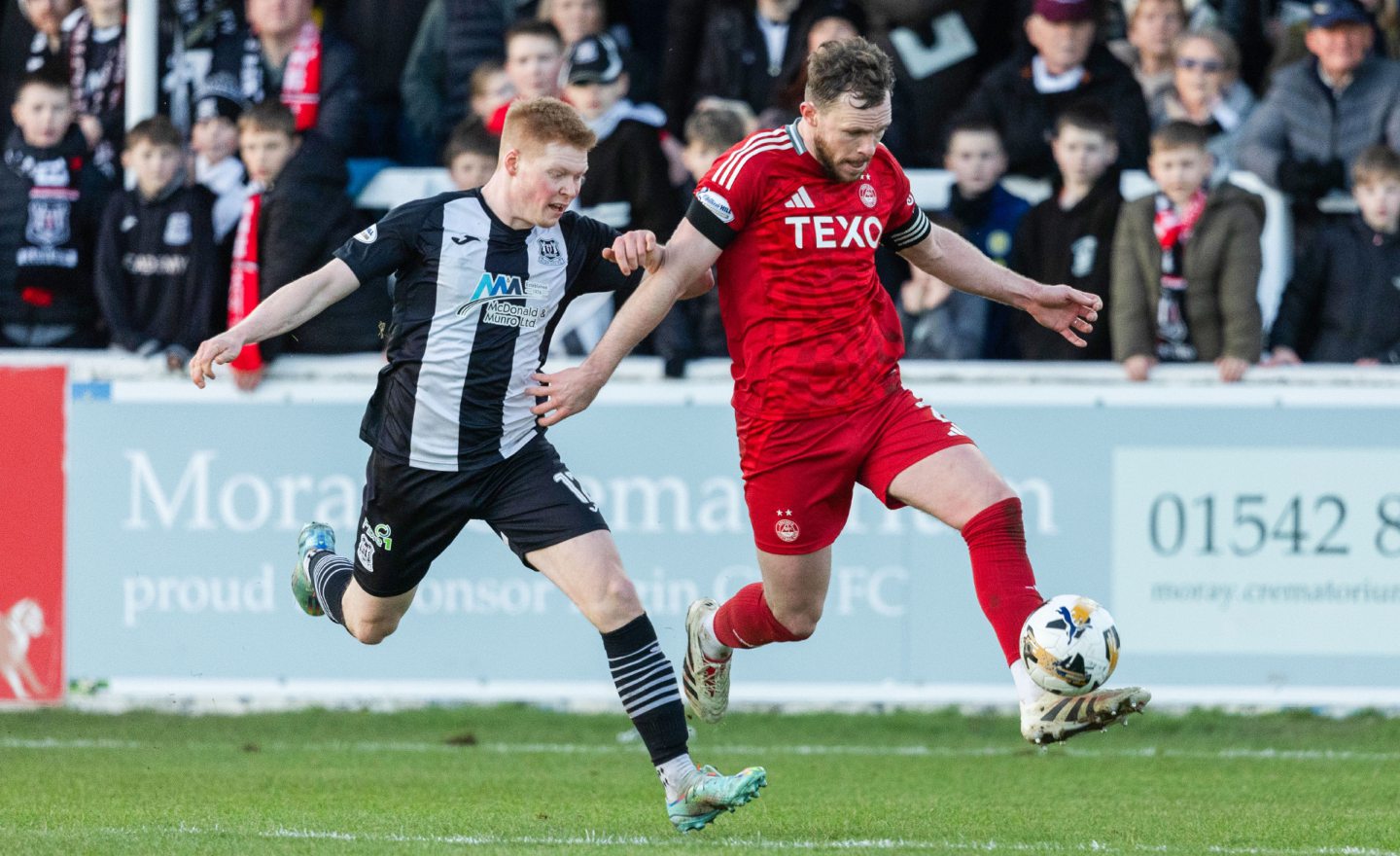 : Elgin's Owen Cairns and Aberdeen's Nicky Devlin in action . Image; SNS 