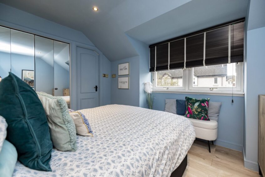 Walls, ceiling and skirtings showcase a blue colour-drench technique in a bedroom.