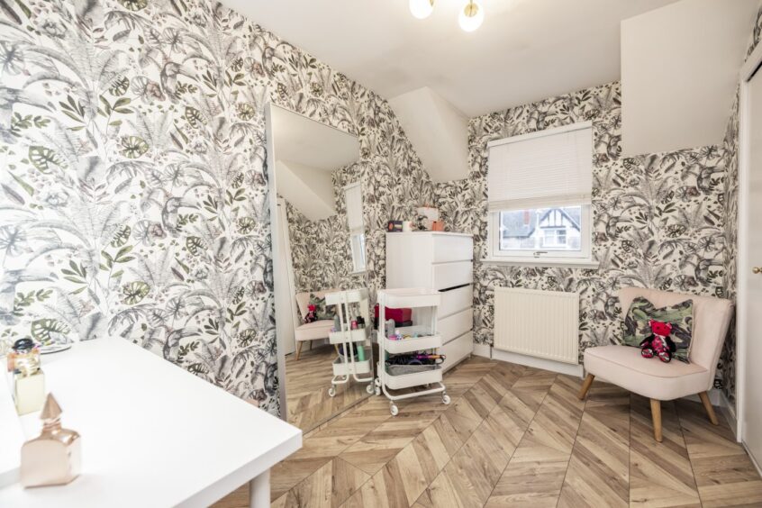 Bedroom three. with feature wallpaper and light furnishings, is currently used as a dressing room.