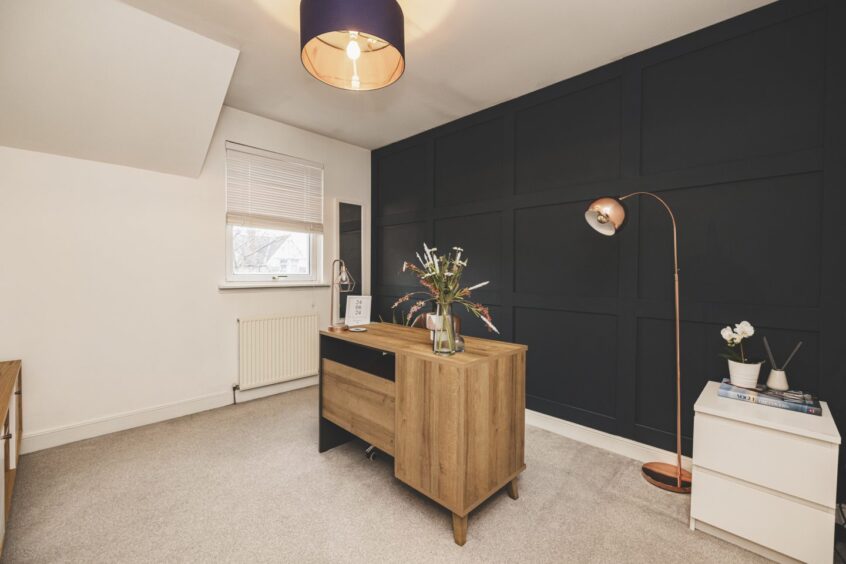 A bedroom with attractive wall panelling can alternatively be used as a home office.