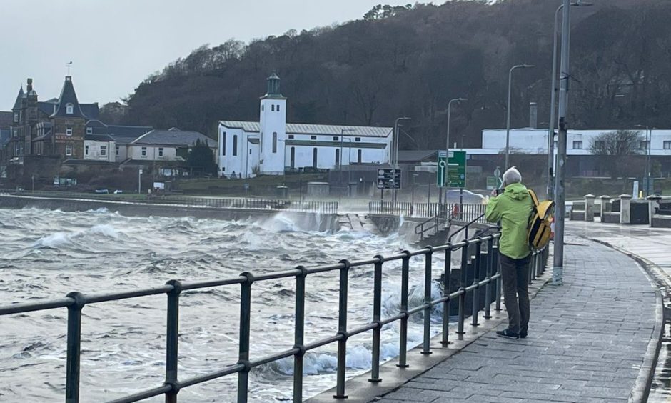 A tourist on the Esplanade in Oban during Storm Eowyn.