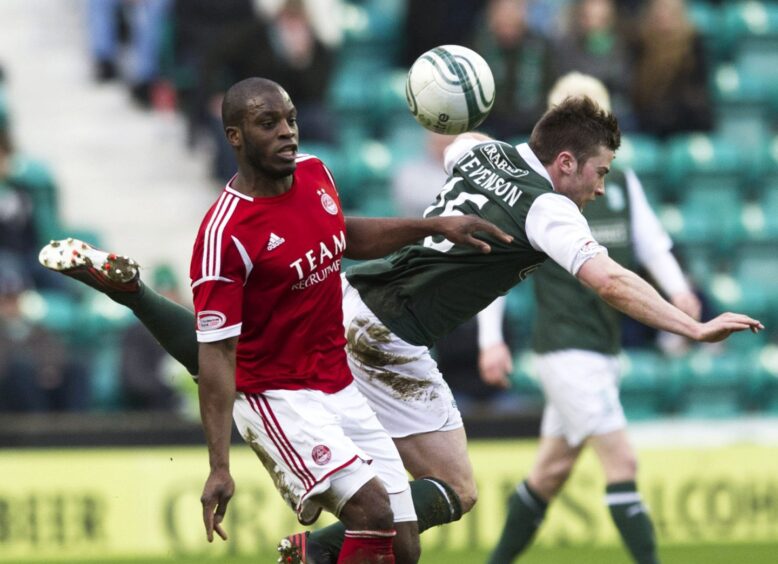 Isaac Osbourne (left) outmuscles Hibernian's Lewis Stevenson as Aberdeen FC take on Hibs in February 2013.