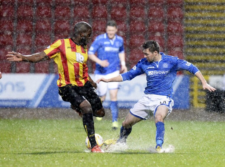 Partick Thistle's Isaac Osbourne (left) goes for the ball with St Johnstone's Gwion Edwards as spray flies up off the pitch