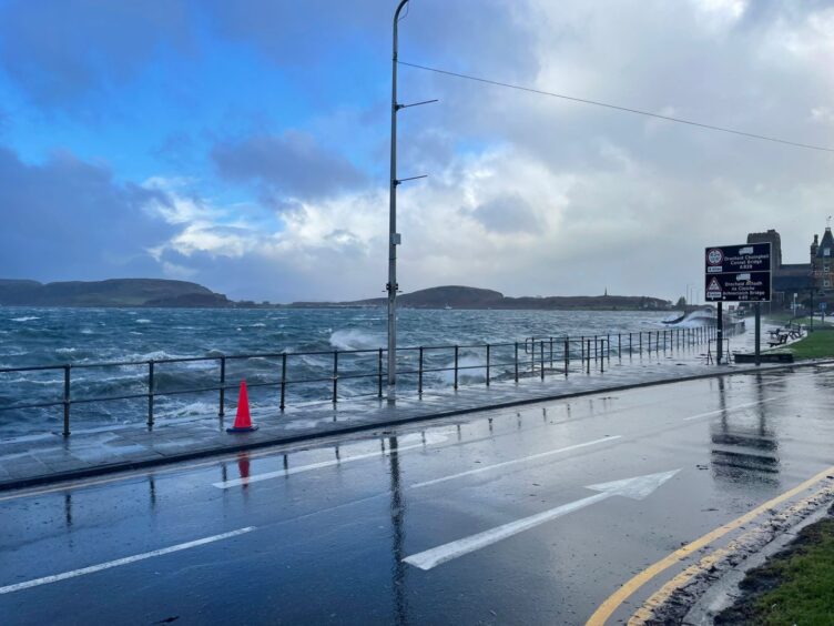 Fierce waves threaten to swamp a road in Oban, driven in by Storm Eowyn.