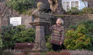 Gwynne McKay, secretary of the Stonehaven ‘Fatherland’ Burns Club, beside the bust of Robert Burns in the town's memorial garden. Image: Darrell Benns/DC Thomson.