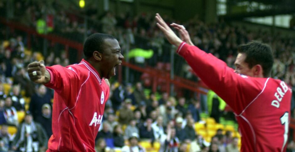 Leon Mike celebrates a goal with Derek Young.