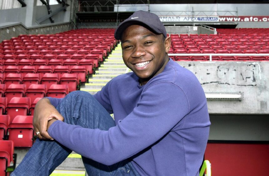 a smiling Leon Mike is pictured in the stand at Pittodrie.