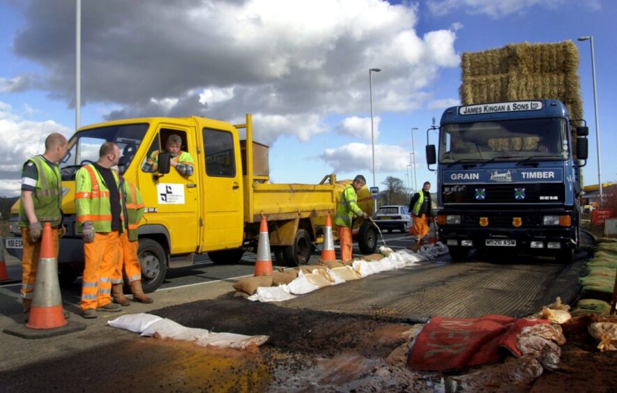 A truck loaded with hay-bales passes through a disinfectant roadblock in Scotland in 2001.