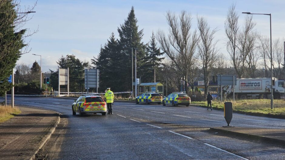 A number of police vehicles can be seen behind the cordon, next to the Tesco supermarket at Inshes.