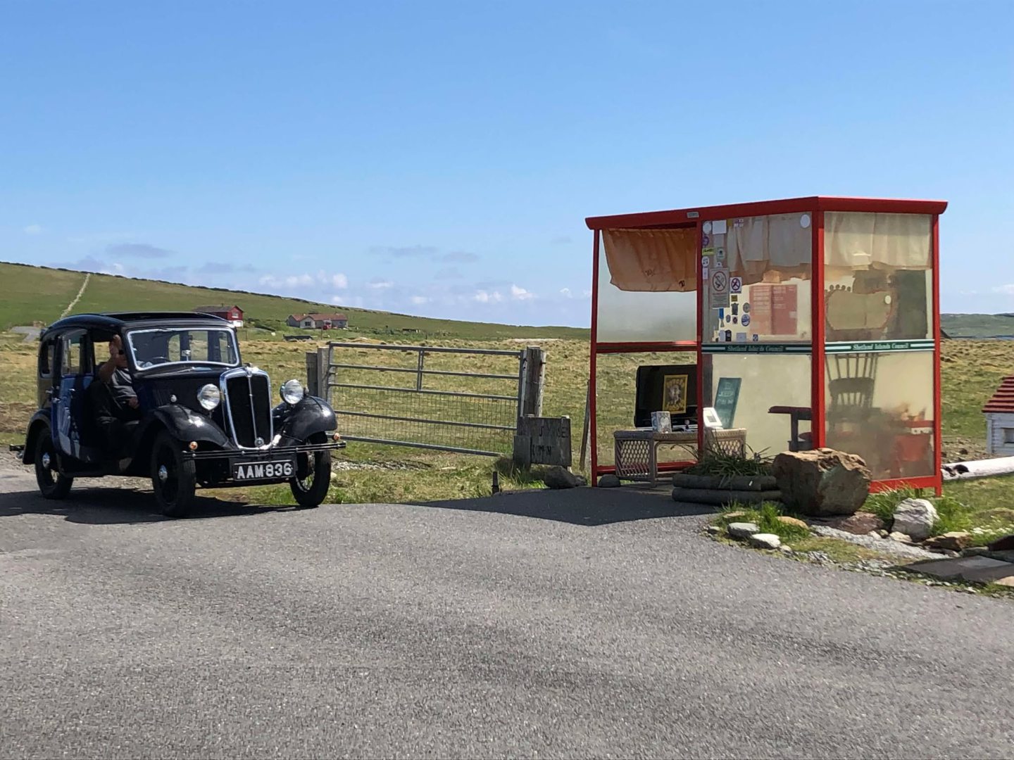 Bobby's Bus Shelter in Unst, Shetland with a vintage car parked outside. 