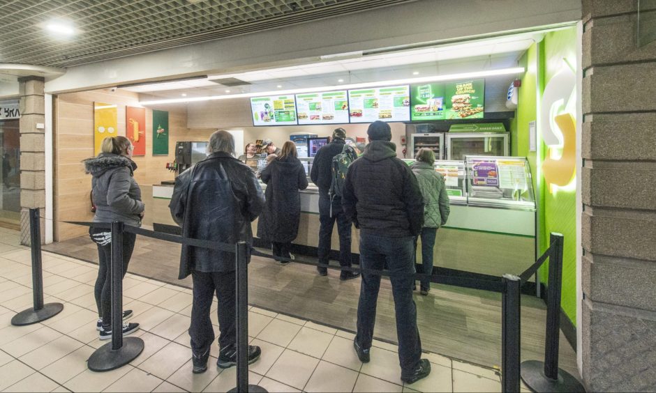 Customers queuing at Subway. 