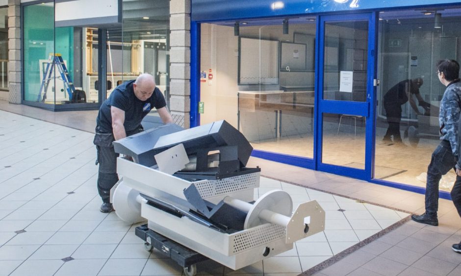 Equipment being pushed from shopping centre. 