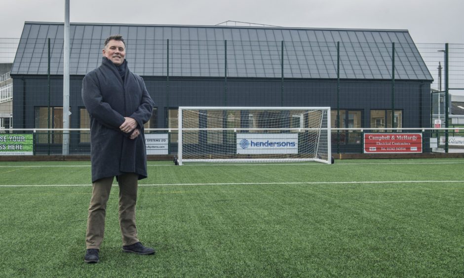 Dave Allen standing on football pitch. 