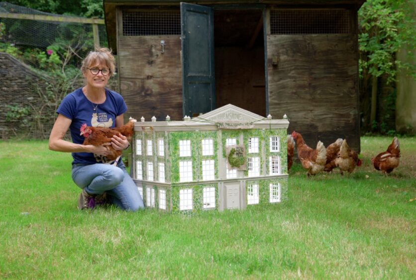 British Hen Welfare Trust founder and chief executive Jane Howarth with the charity's millionth rehomed hen and a model of its new home with the King. 