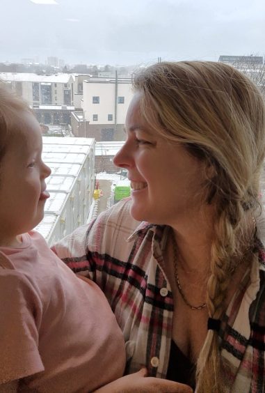 Vicky Pringle looks at her daughter at a window in Aberdeen hospital. 