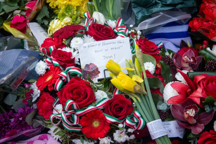 A close-up of floral tributes laid at the Denis Law statue.