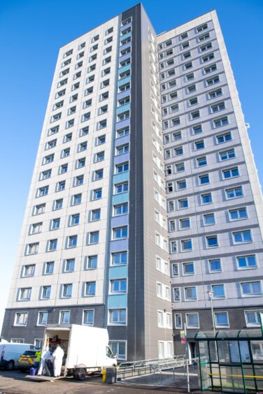 The Aulton Court high-rise, where a police vehicle can be seen together with a white van used by clean-up teams.