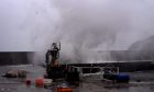 A large wave hits Stonehaven Harbour.