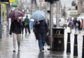 People walking with umbrellas in Inverness.