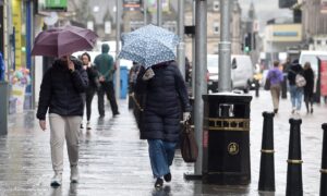 People walking with umbrellas in Inverness.