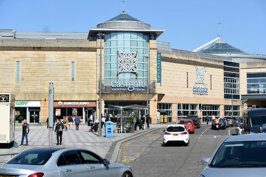 Falcon Square in Inverness with traffic travelling along Academy Street past the bus stance.