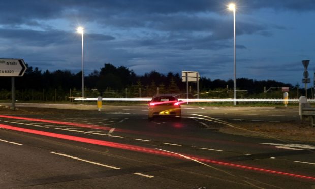 car sits at the Munlochy junction on the A9 waiting to turn right.