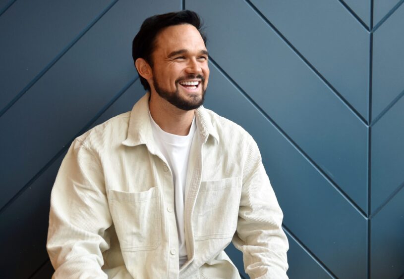 Gareth gates wearing white against a blue background.