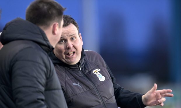 Inverness Caledonian Thistle head coach Scott Kellacher speaks to a member of his coaching staff.