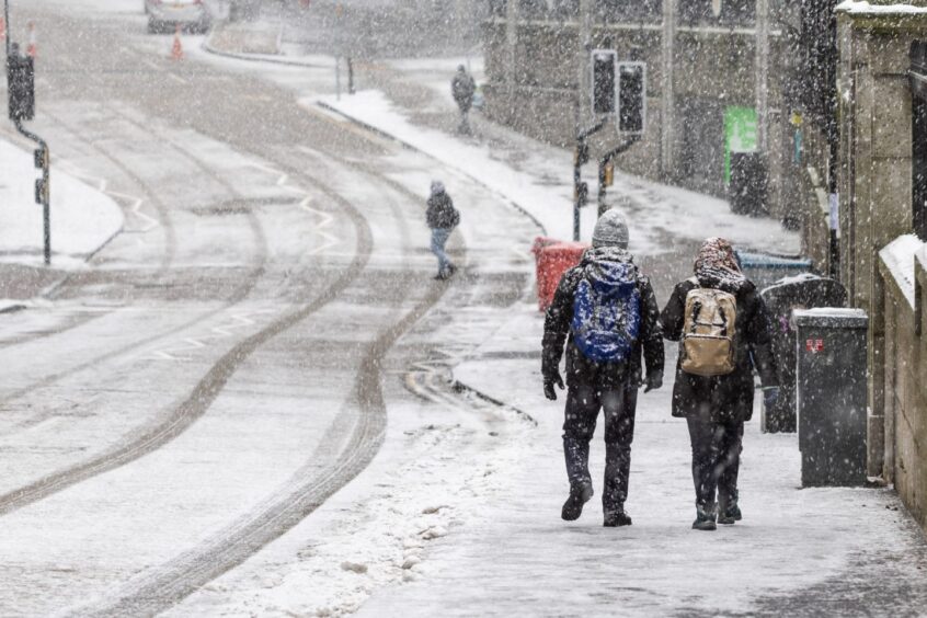 People walking on ungritted pavements around Aberdeen city centre.