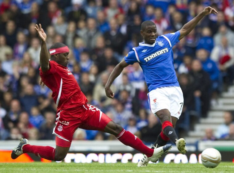 Isaac Osbourne (left) slides in on Rangers' Maurice Edu in 2011.