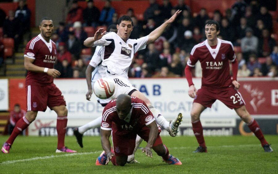 Aberdeen's Isaac Osbourne (below) stoops to head the ball away from Dylan McGowan during one of Derek McInnes' first matches in charge of Aberdeen FC in 2013. 