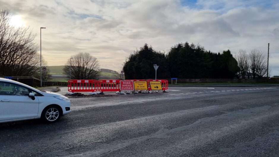 Red and white barriers, a "road closed ahead sign" and directions to the diversion.