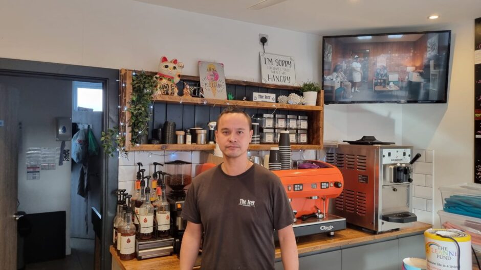 Des Green, owner of The Icer, in his shop and cafe, a large orange coffee machine behind him.