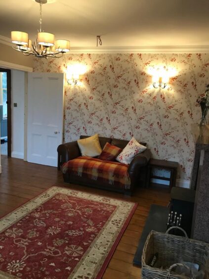 Inverarnie Lodge with rug and sofa.