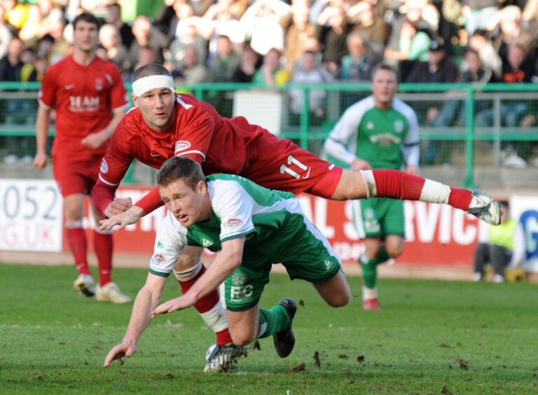 Tommy Wright climbs over David Van Zanten of Hibs in a game at Easter Road in 2009. 