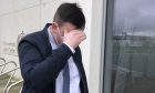 Neil Ross wore a mask and hid his face from our camera as he emerged from court. Image DC Thomson