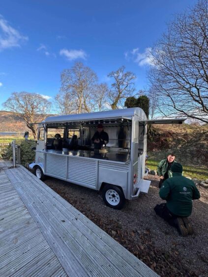 A picture of a new retro food van being installed by two workers at Woodlands Glencoe. 