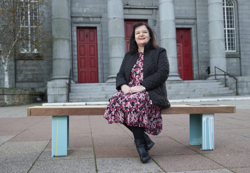 Debra Baxter, nee Kirkness, on a bench in Aberdeen designed in recognition of her work. Image: Craig Williamson / SNS Group.