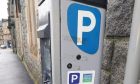 A parking meter in Oban with the proper code and information for paying for parking.