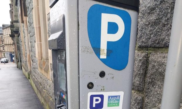 A parking meter in Oban with the proper code and information for paying for parking.