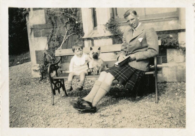 Eoghann Maclachlainn with his dad and dog in Tobermory.