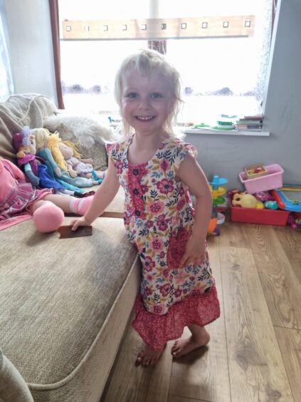 Pictured is three year old Phoebe in a pink and white dress.