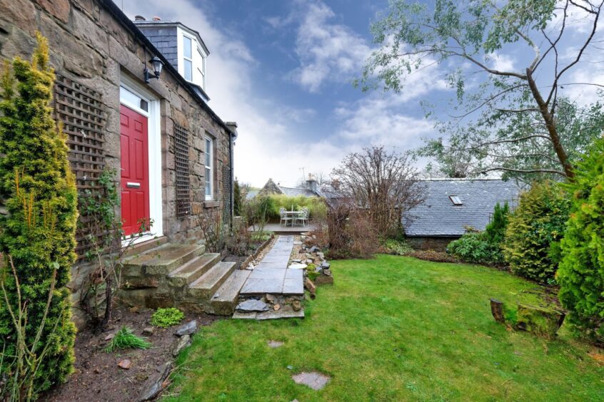 The outside space, with lawns, paths and planting.