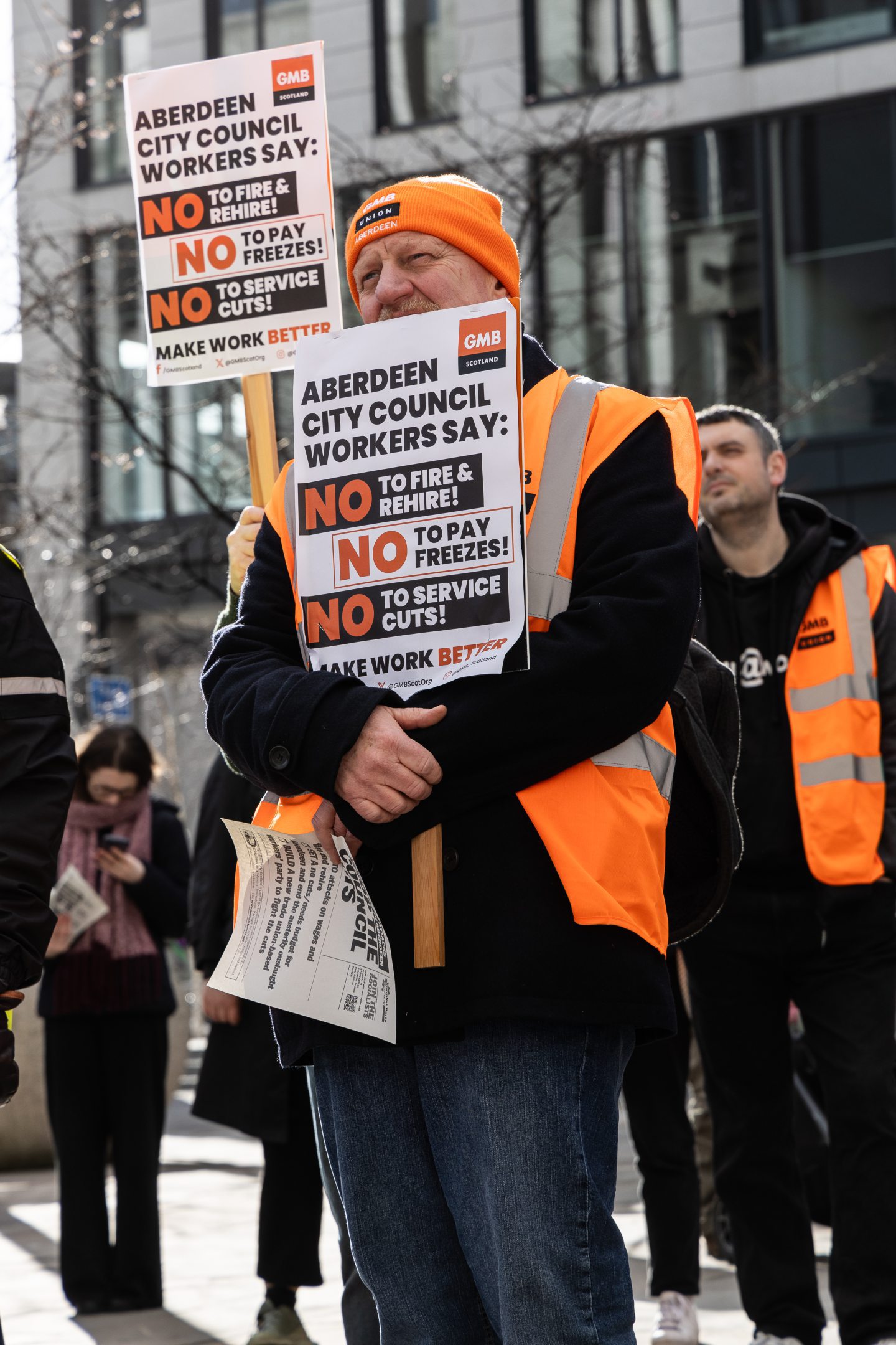 Protestor holding sign against fire and rehire 