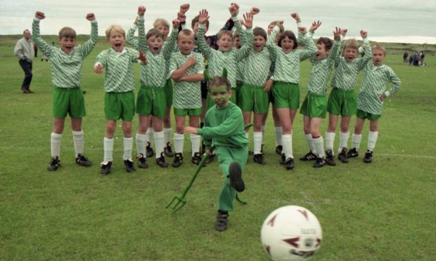 Champion Street 1996 -Dubford Devils mascot Daniel Hendry, 7, displays his shooting power, cheered on by his squad members (from left) Nicholas Wood, Craig Clarkson, Alex Stephen, Timon Scheven, Cameron McCombie, Scott Longthorne, Callum Stewart, Graeme Skene, Chris Hendry, Tom Norcott, Jill Robertson, James Pinsent, David Skene, James Copland.