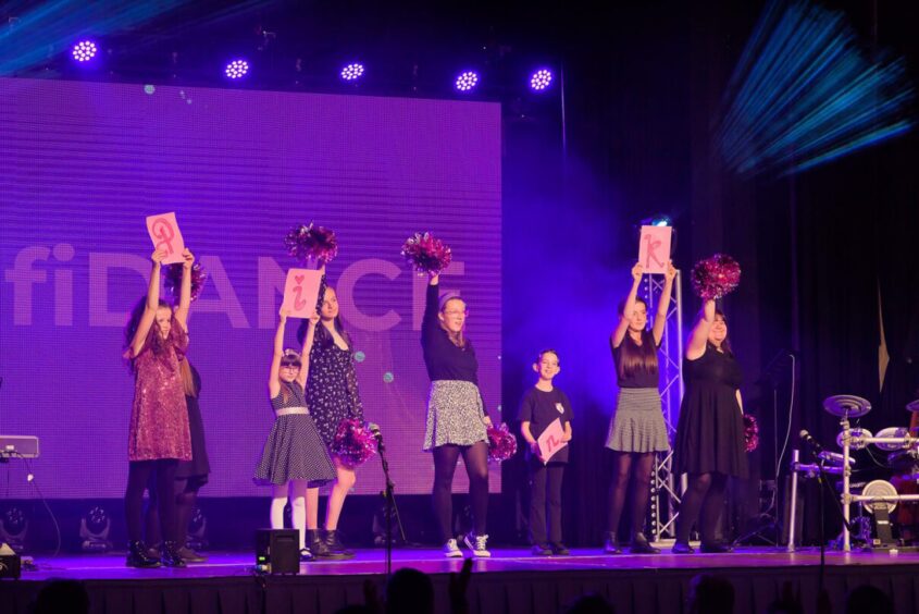 children signing and dancing on stage