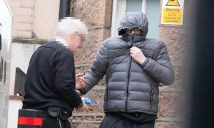 Grant McDonald covers up as he arrives at Peterhead Sheriff Court. Image: DC Thomson