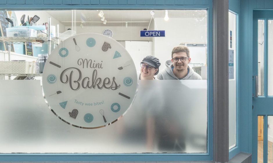 Ruby and Lewis Smart looking through Mini Bakes window. 